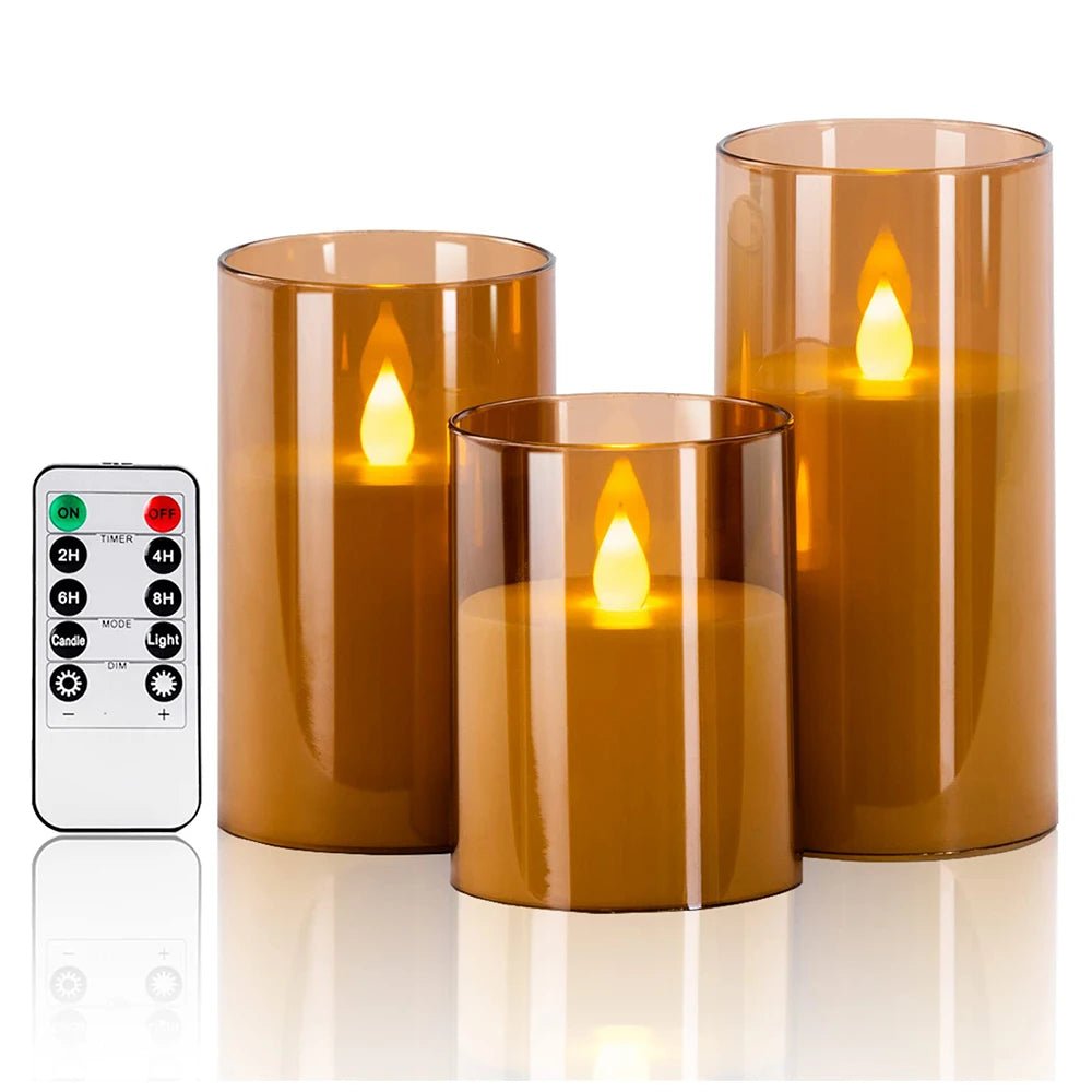 Set of three amber-colored LED candles with a remote control on a white background